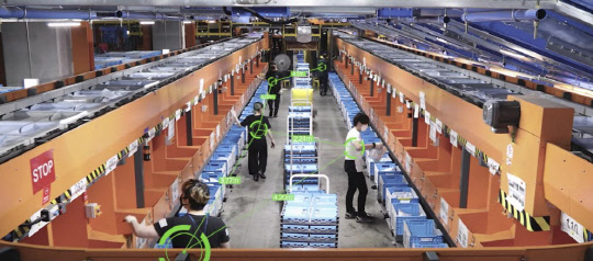 쿠팡 물류센터 직원들이 코로나19 감염 예방을 위해 거리두기를 유지하며 상품을 정리하고 있다. 쿠팡 제공